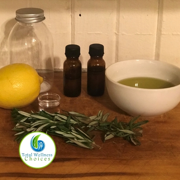 bath oil recipe set  up with herbs, lemon and oil next to a bowl