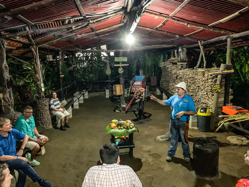 a man explaining the process of making fresh sugar cane juice at arenal vida campesina