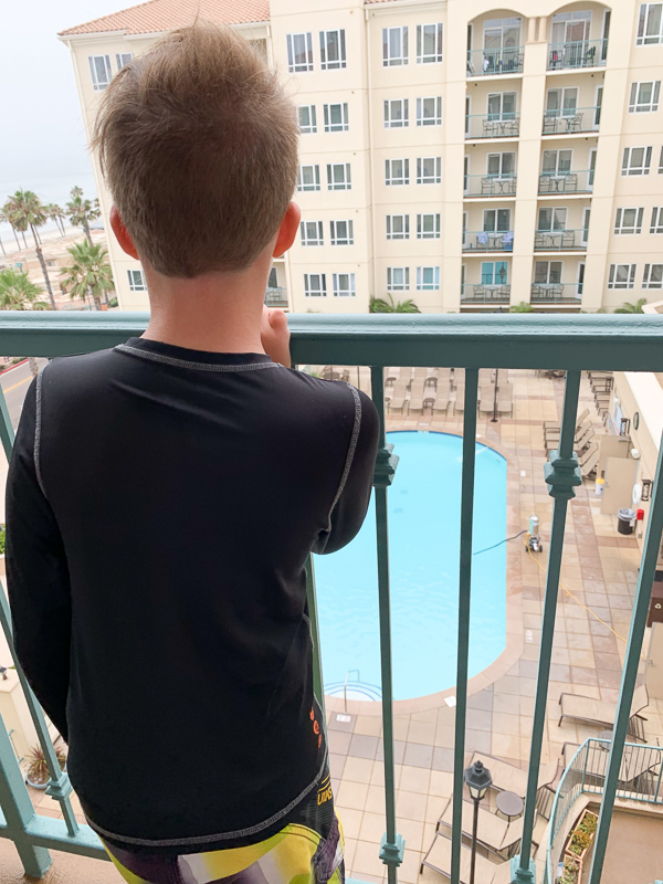 a boy on the balcony view the pool