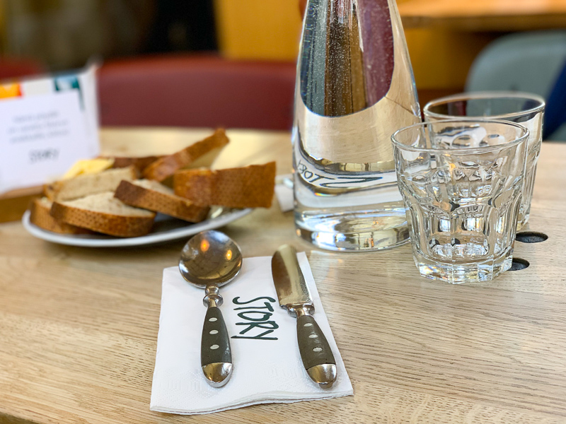 silverware on table at restaurant with bread and water