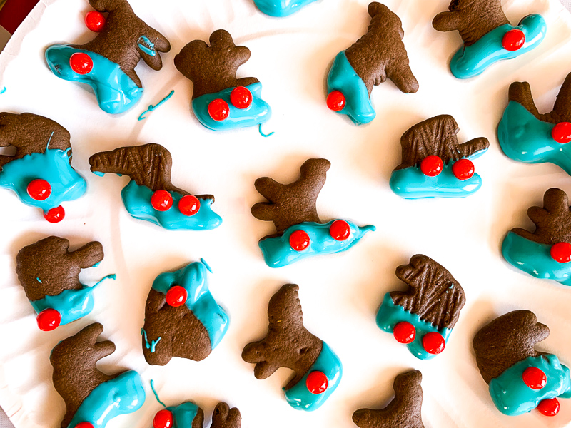 chocolate animal cookies with blue candy melts melted on them and red candies for eyes