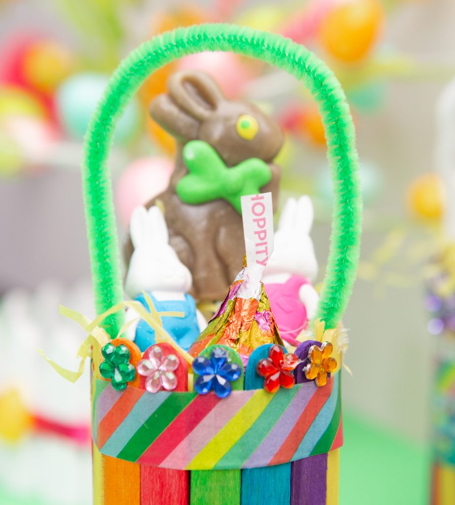 green pipe cleaner attached to mini Easter basket with goodies inside