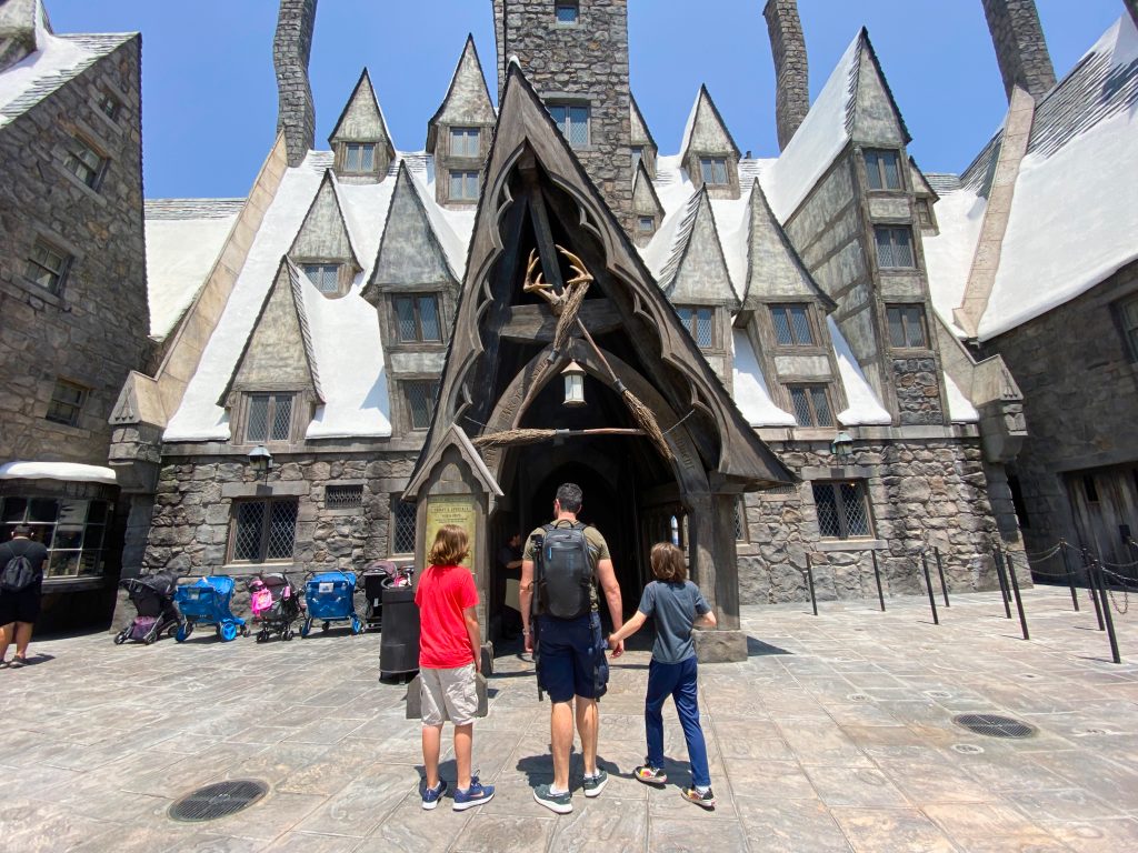 father and two boys walking into Three Broomsticks at Universal Studios Hollywood™