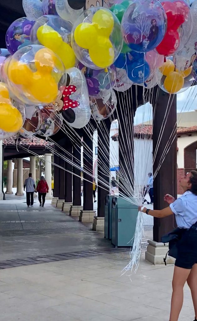 girl at Disney Springs holding balloons